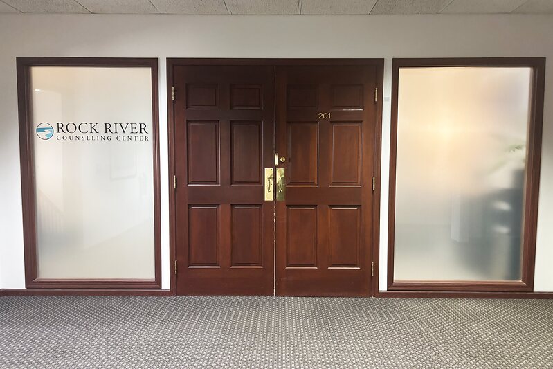 The Rock River Counseling Center entrance — double doors marked Suite 201 with the logo on the frosted glass